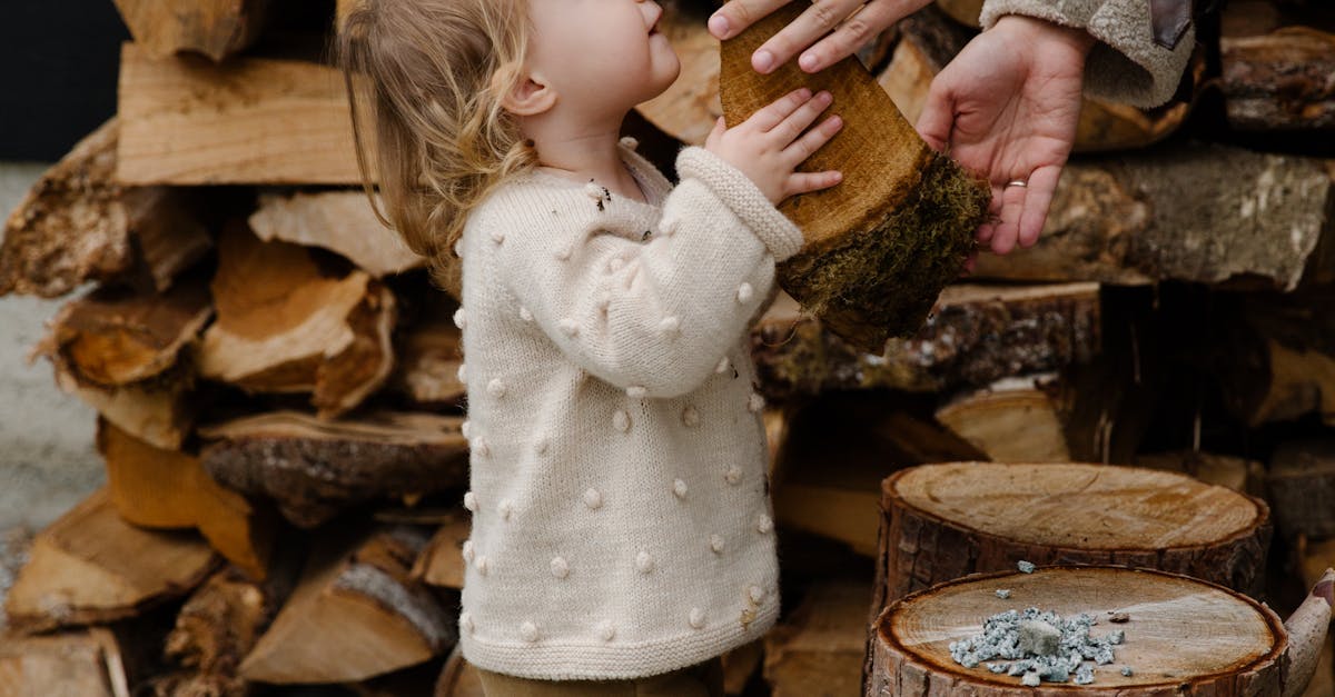 Little girl looking at father standing near firewood