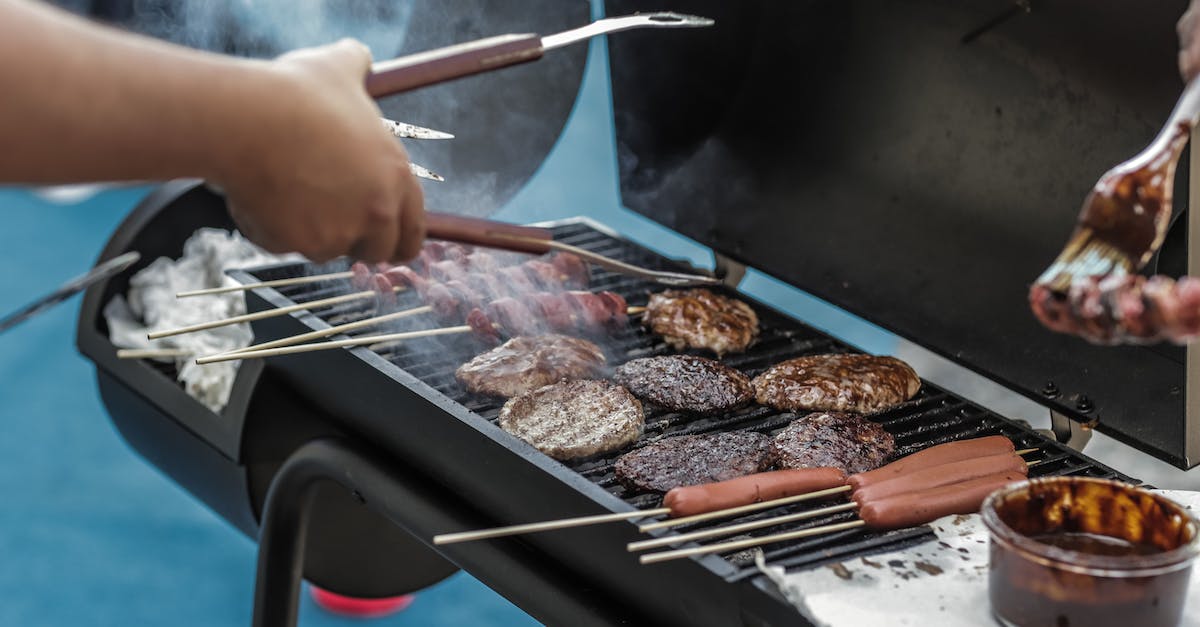 Person Grilling Sausage and Meat