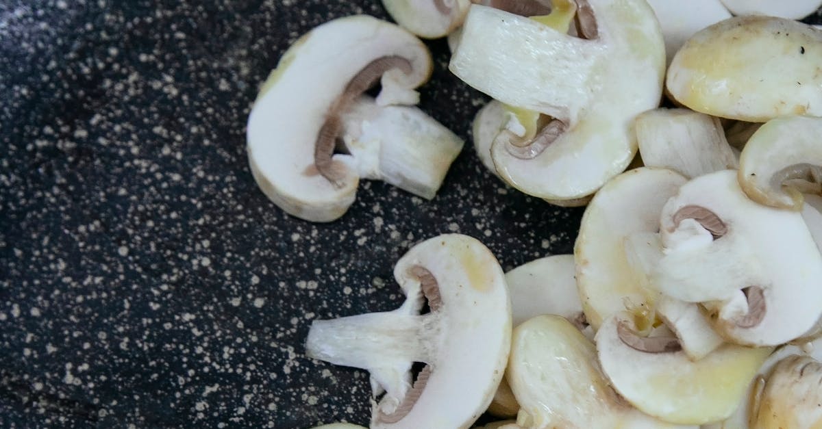 Sliced champignons with oil in frying pan