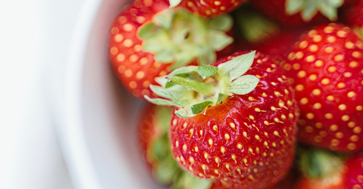 Ripe strawberries in white plate on table