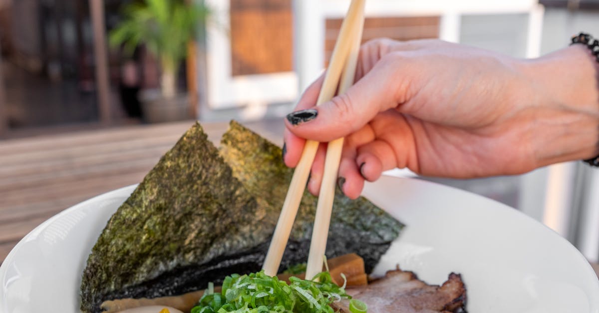 A person holding chopsticks in a bowl of food