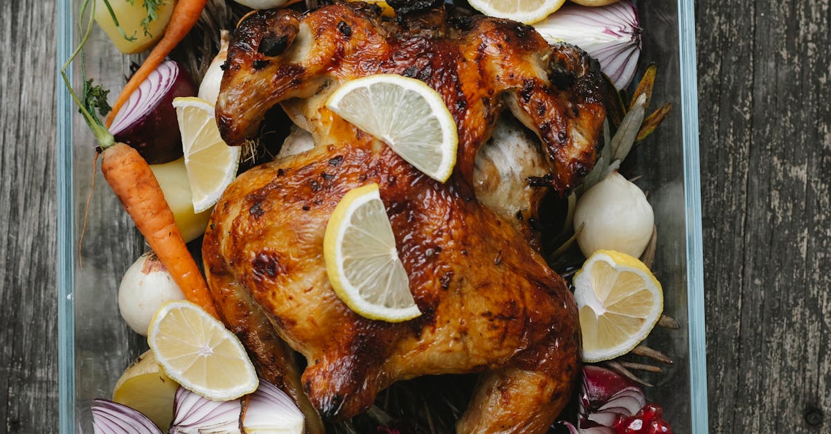 Tasty baked chicken with vegetable and fruit mix on table