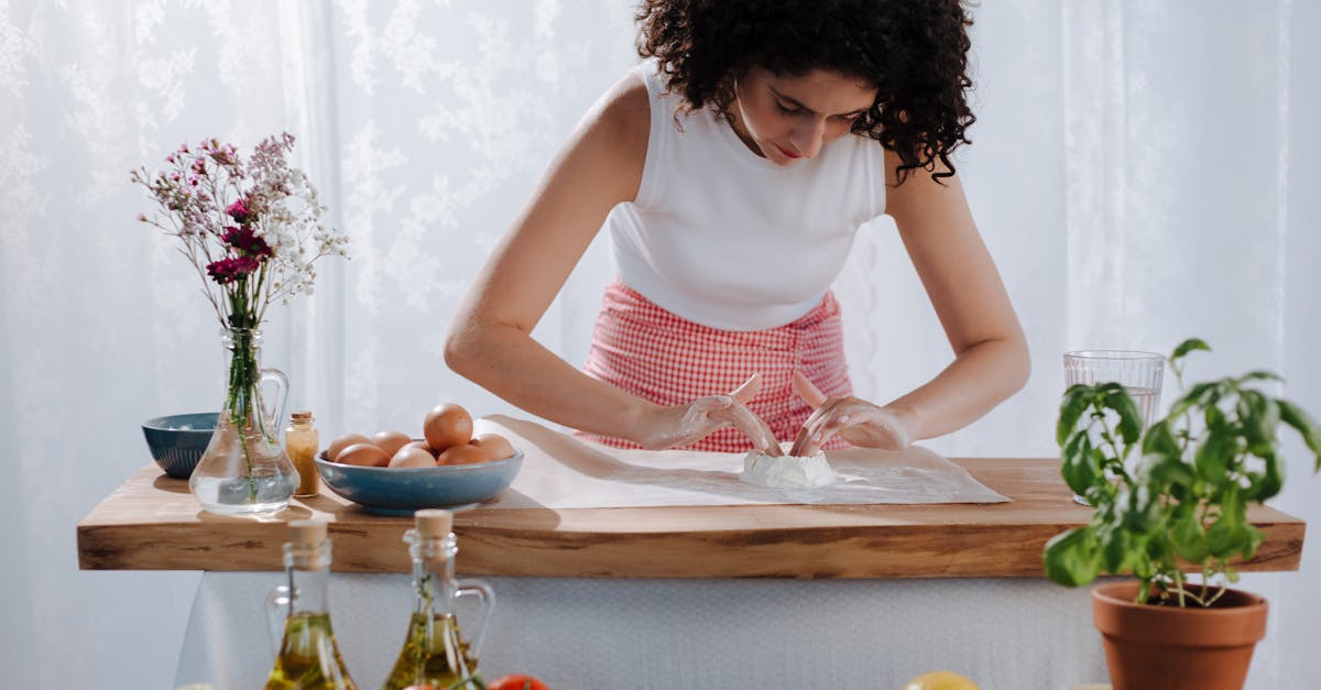 Young Woman Mixing Pasta Ingredients on Kitchen Table