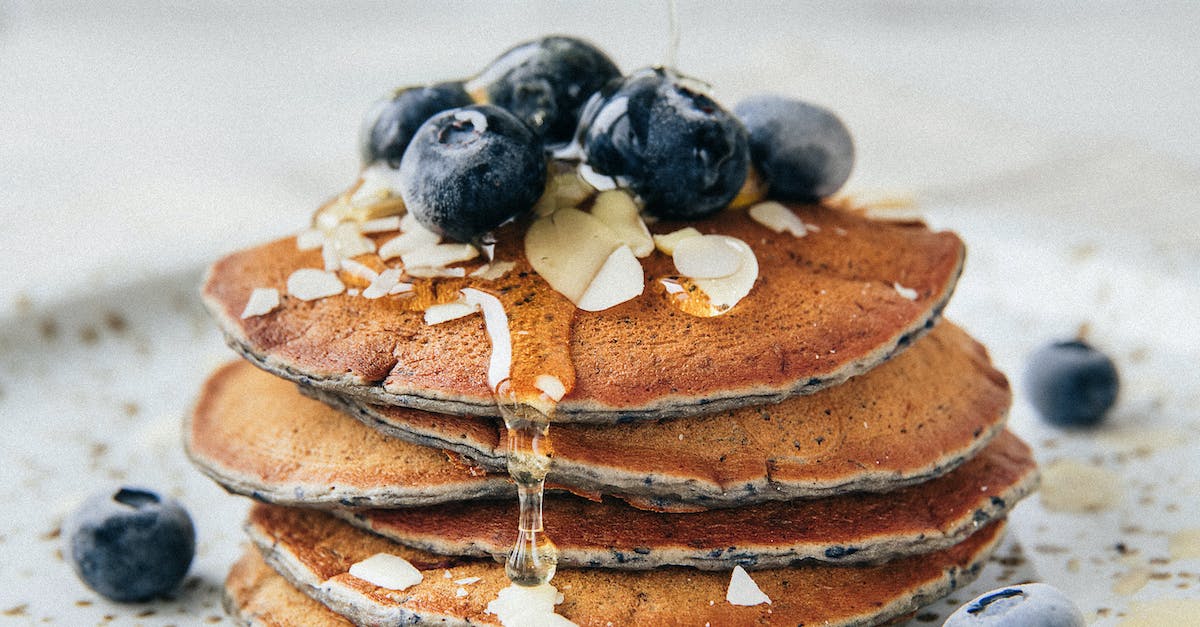 Stack of Pancakes Garnished with Blueberries and Almond Flakes Presented on Plate 