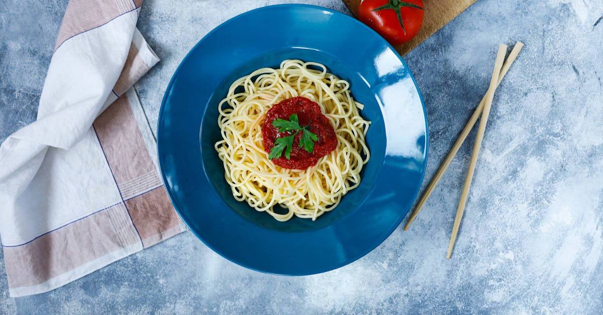 A plate of spaghetti with tomatoes and a fork