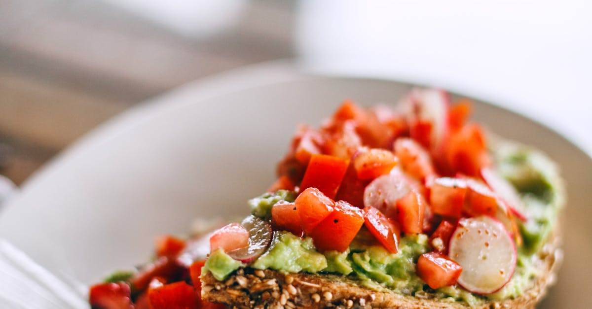 Delicious sandwiches with avocado and juicy tomato slices on rye bread pieces with sesame seeds