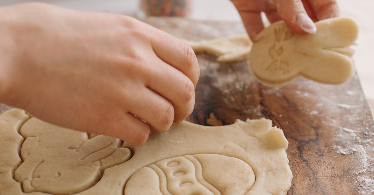 Person Holding Brown Dough on Brown Wooden Table