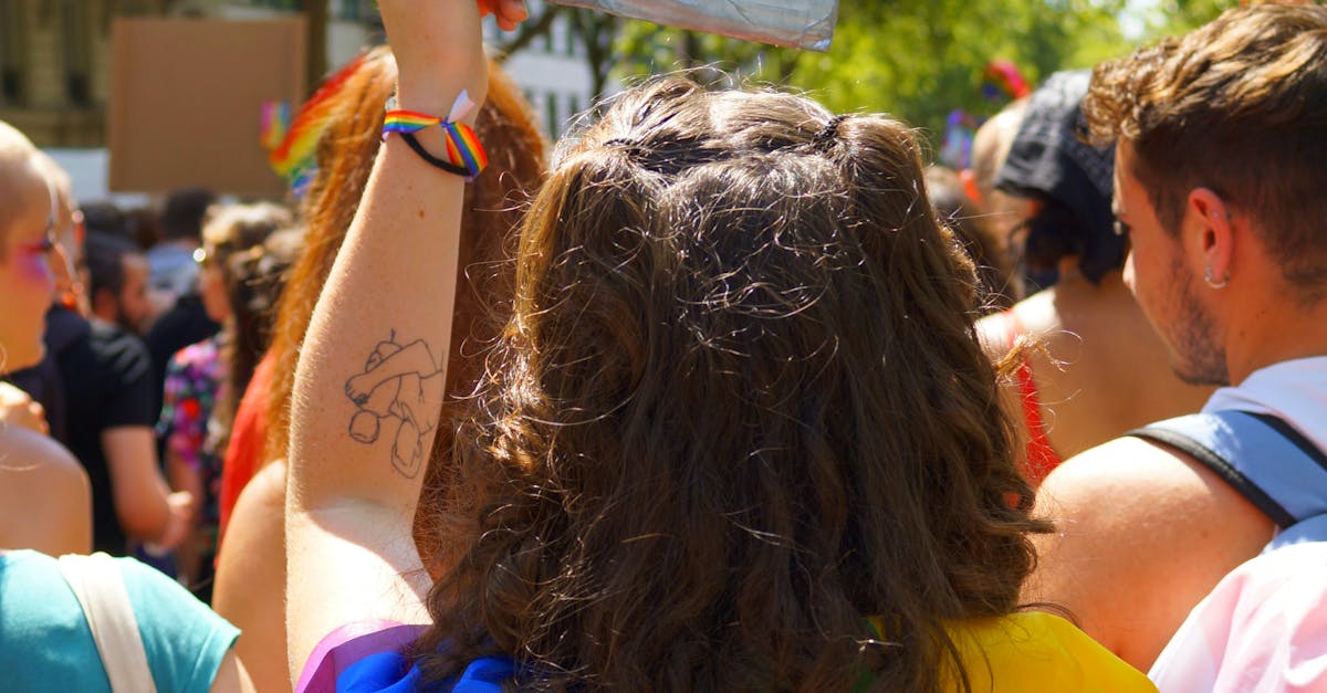  Person with a Rainbow Flag on Back and a Banner in Hand