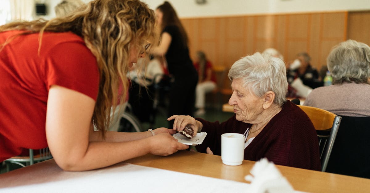 Seniorka s pečovatelkou u odpolední kávy a zákusku