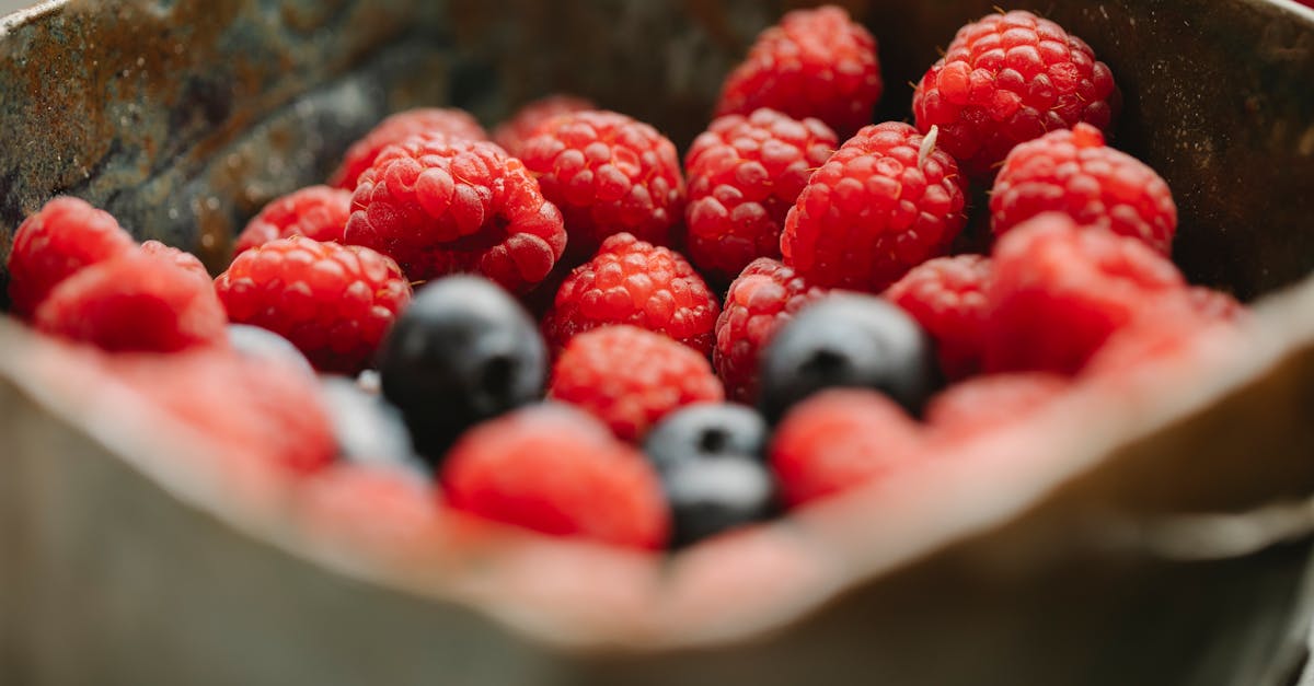 Appetizing ripe raspberries and blueberries in bowl