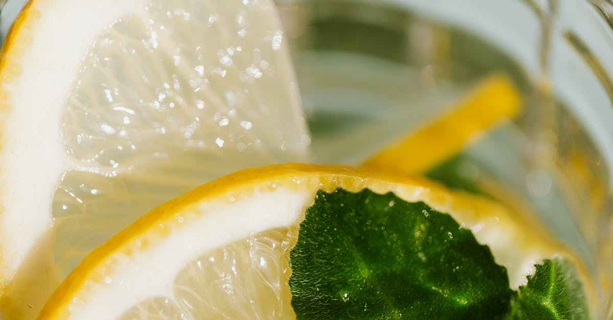 From above of glass of fresh cocktail made of mint leaves and slices of lemon