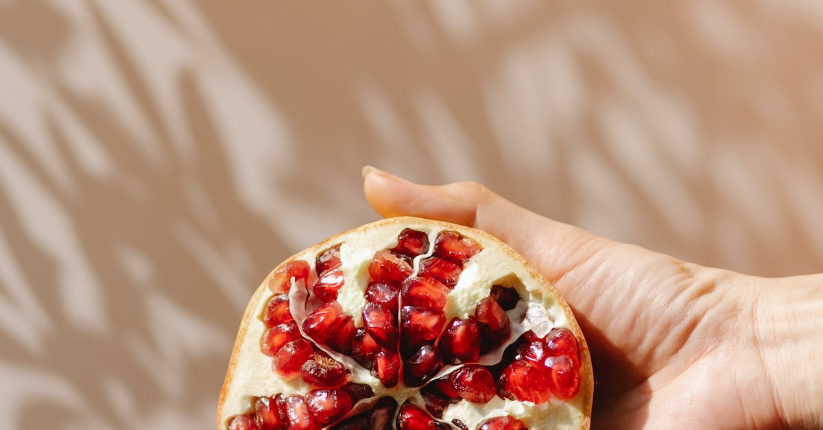 Crop woman demonstrating ripe pomegranate